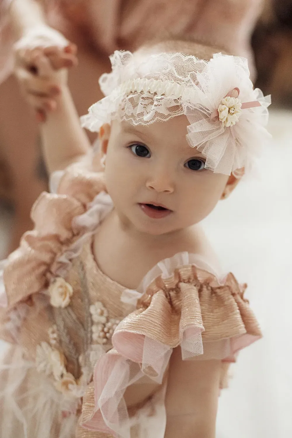 małe dziecko ubrane w eleganckie jasne ubranie do chrztu