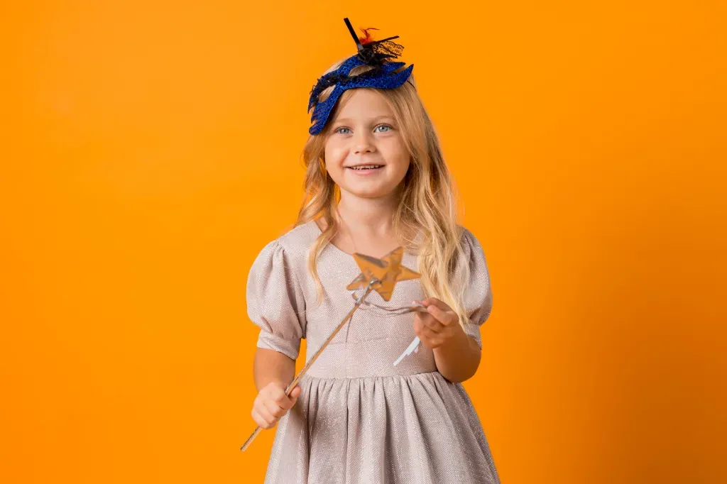 dziewczynka w kostiumie wróżki z różdżką w ręce