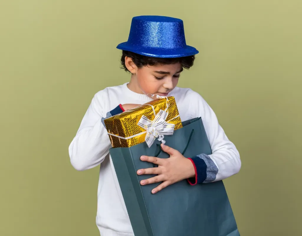 chłopiec w kostiumie magika trzyma torbę z prezentami